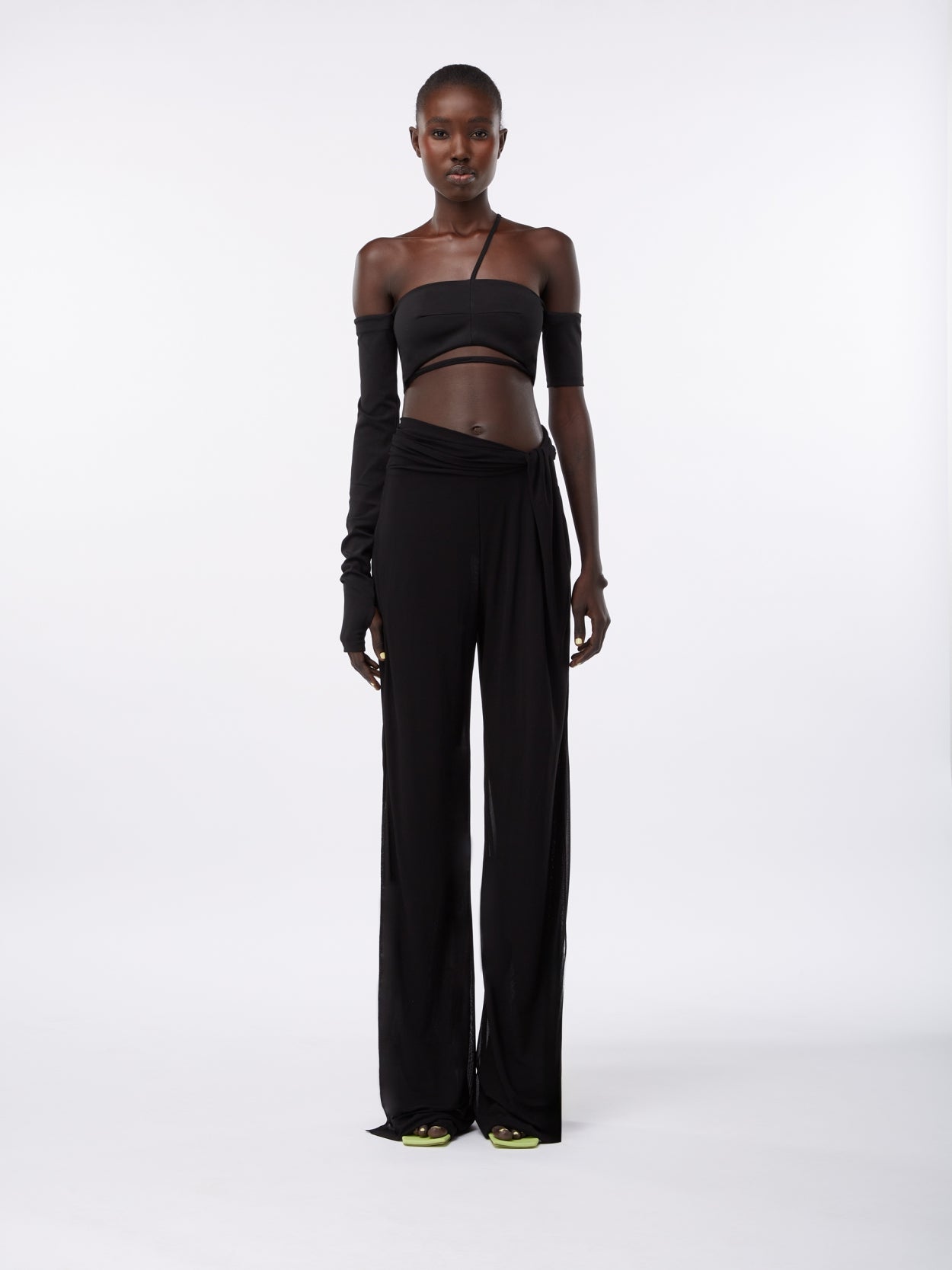 model wearing black draped trousers with twist detaill
