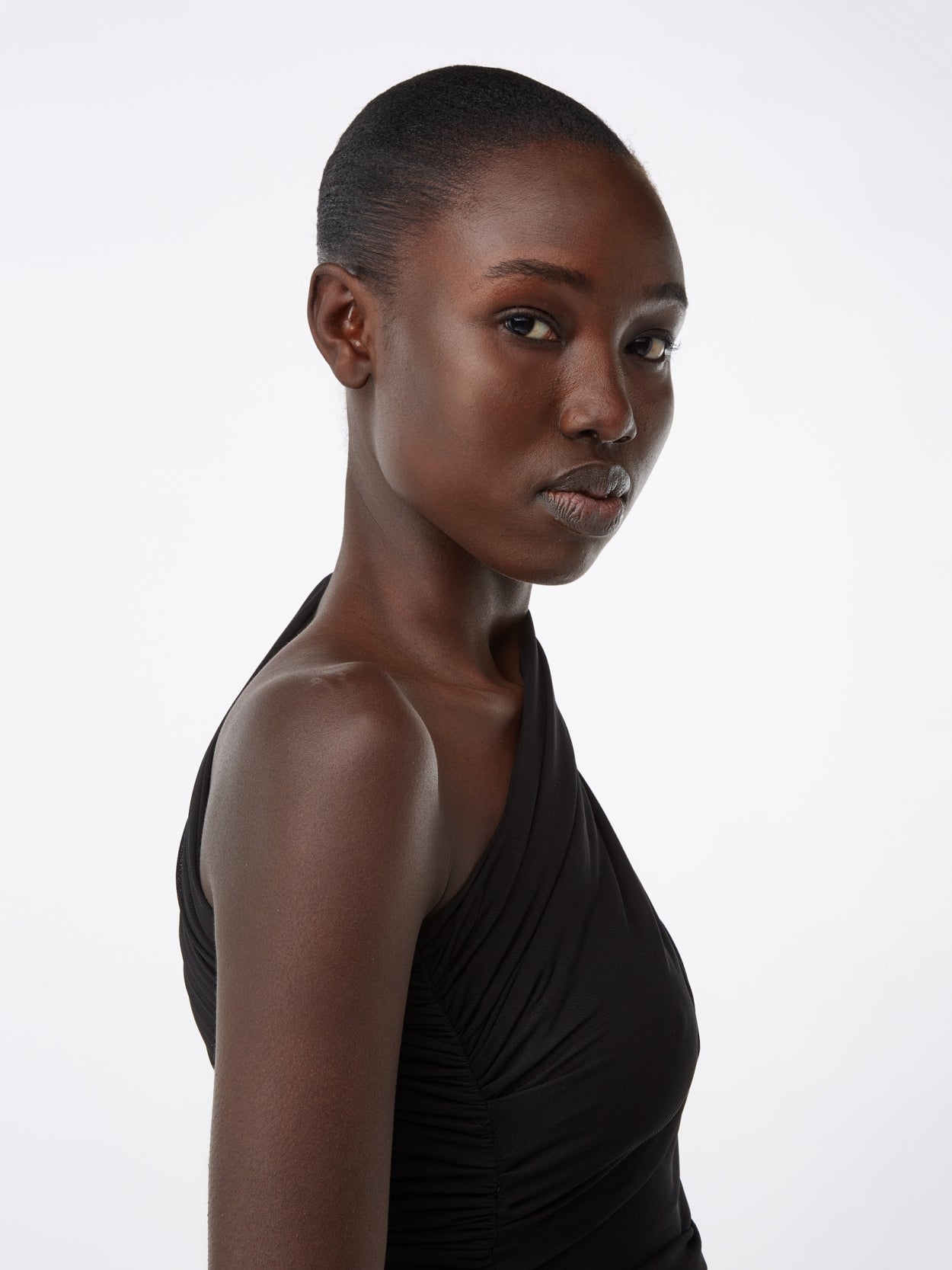 model wearing a one sleeve black draped dress