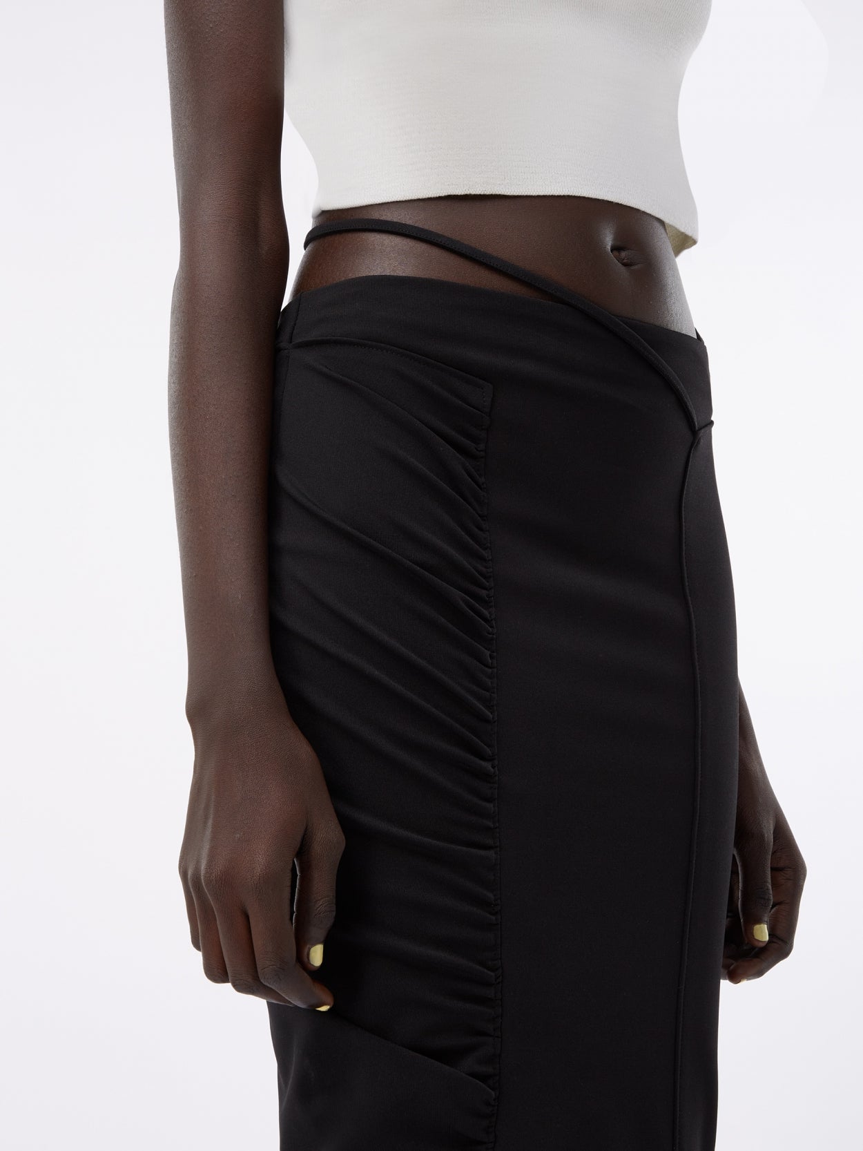 detail of a black midi pencil skirt with waist strap